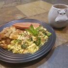 Tofu scramble with shepherd's needle, basil, zucchini, and green pepper, alongside potatoes and veggie bacon