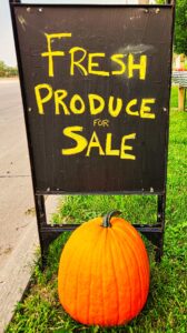 Sign painted with chalkboard paint, fresh produce for sale, with pumpkin in front