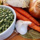 Ingredients for pea soup (dried split peas, garlic clove, bay leaves, carrots, onion)