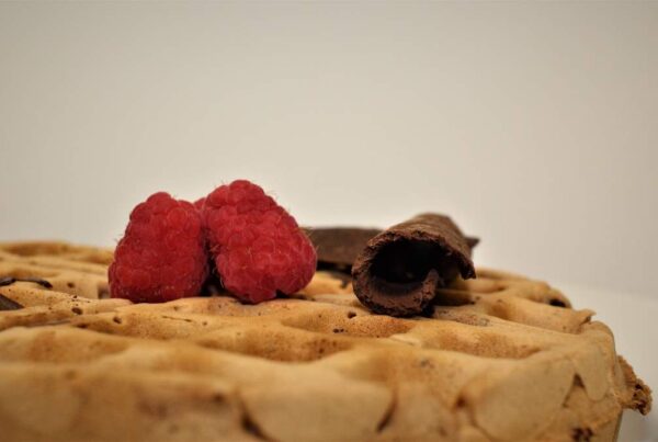 Waffle with homemade chocolate decor and fresh raspberries